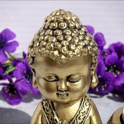 Detaljeret t�t billede af hovedet p� den lille gyldne Buddha fyrfadsstage.