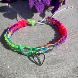 Armbnd, hndlavet af Krystal Oasen med bjergkrystal (6,5 mm) og slvfarvet hjerte charm. Justerbar regnbuefarvet og hvid nylonsnor, ca. 7 mm bredt.