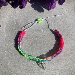 Armbnd, hndlavet af Krystal Oasen med bjergkrystal (6,5 mm) og slvfarvet hjerte charm. Justerbar regnbuefarvet og hvid nylonsnor, ca. 7 mm bredt.