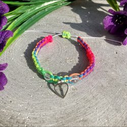 Armbnd, hndlavet af Krystal Oasen med bjergkrystal (6,5 mm) og slvfarvet hjerte charm. Justerbar regnbuefarvet og hvid nylonsnor, ca. 7 mm bredt.