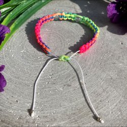 Armbnd, hndlavet af Krystal Oasen med bjergkrystal (6,5 mm) og slvfarvet hjerte charm. Justerbar regnbuefarvet og hvid nylonsnor, ca. 7 mm bredt.