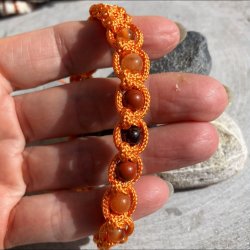 H�ndlavet knyttet armb�nd inspireret af Mars med granat, r�d jaspis, r�d aventurin og karneol i varm orange nylonsnor.