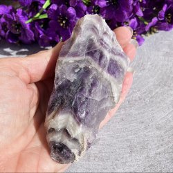En r�, aflang Chevron Ametyst unika krystal, der holdes lodret i h�nden for at illustrere dens st�rrelse og naturlige form.