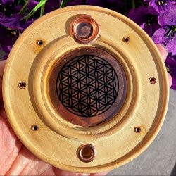 Rund r�gelsesholder i lyst tr� med det spirituelle symbol Livets Blomst p� en metalplade i midten.