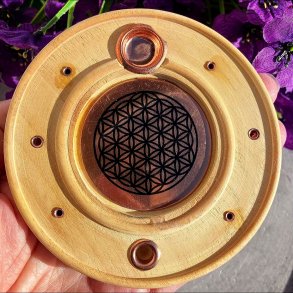 Rund r�gelsesholder i lyst tr� med det spirituelle symbol Livets Blomst p� en metalplade i midten.