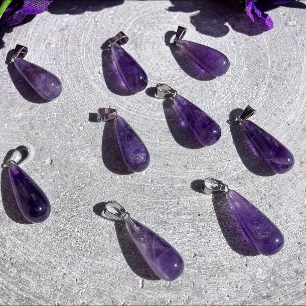 En samling af polerede ametyst dr�be vedh�ng for at vise de naturlige variationer i de lilla krystallers nuancer